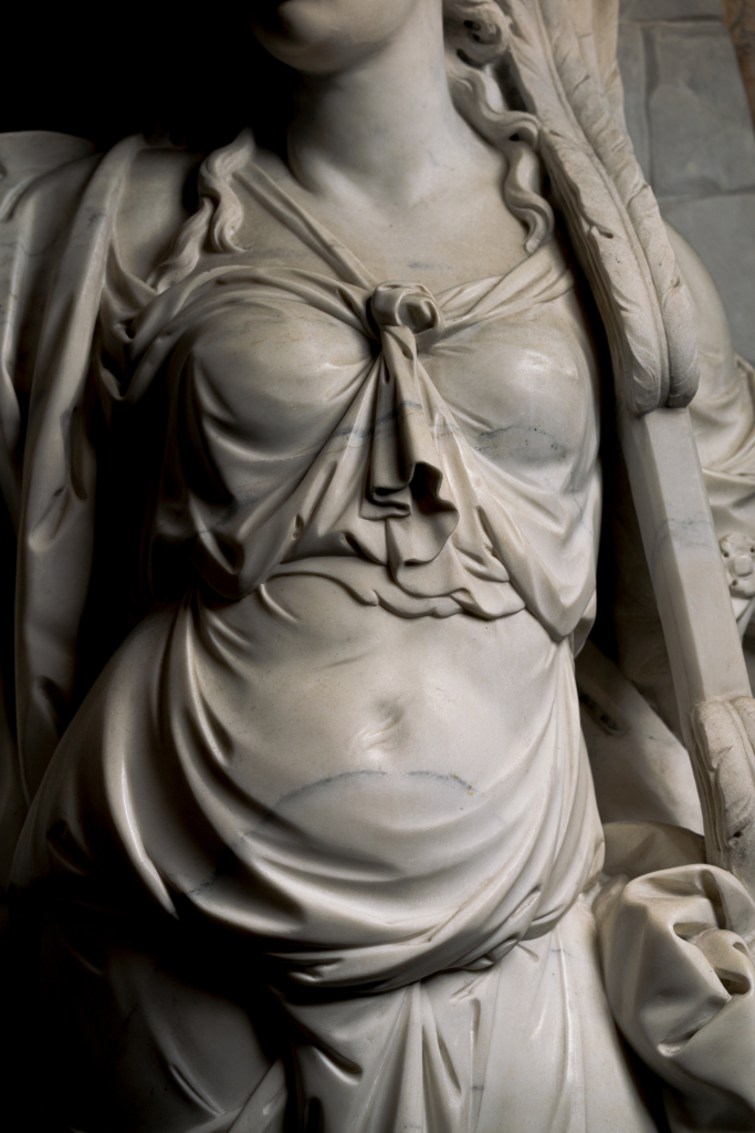 dettaglio Statua Soavità del giogo coniugale: ventre e busto della donna, vestito drappeggiato, giogo piumato